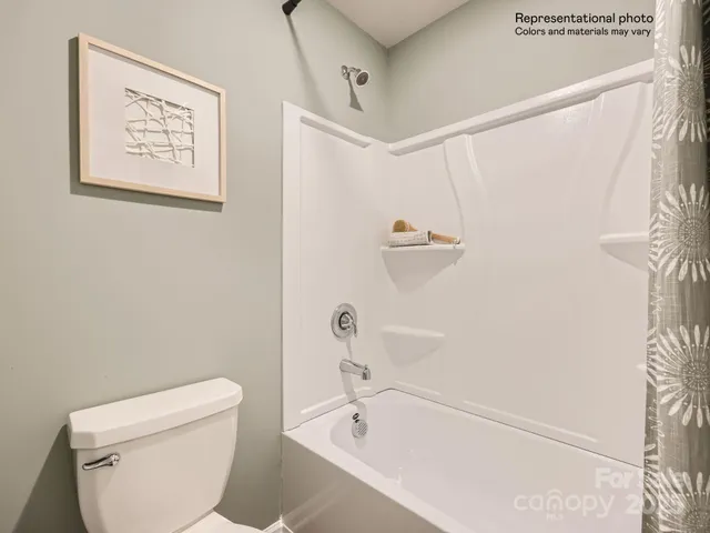 a white toilet sitting next to a bath tub