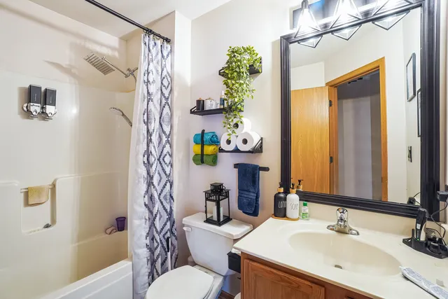 a bathroom with a sink a toilet and shower curtain
