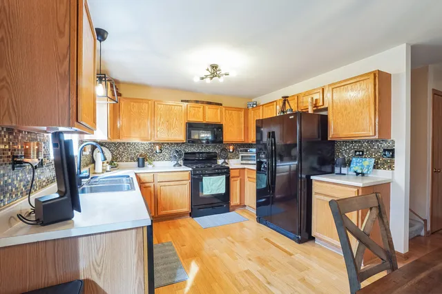 a kitchen with a refrigerator and wooden cabinets
