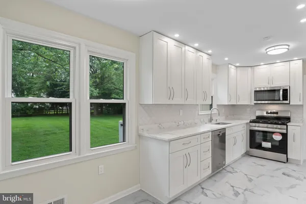 a kitchen with stainless steel appliances a refrigerator and a stove top oven