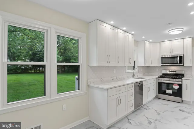 a kitchen with stainless steel appliances a refrigerator and a stove top oven