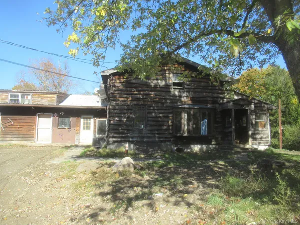 a front view of a house with a tree