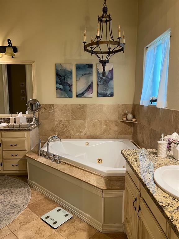 1625 Roma Lane Allen, TX 75013 - Photo 8 of 10 Corner soaking tub with jets, set within a stone-tiled surround