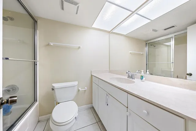 a bathroom with a toilet sink a mirror and vanity