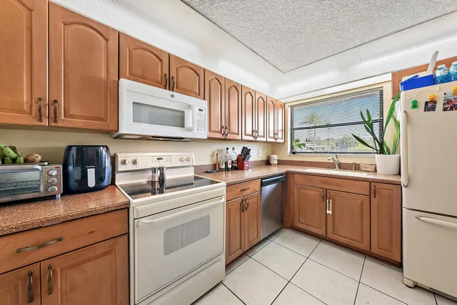 a kitchen with cabinets stainless steel appliances and a sink