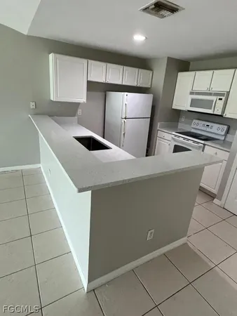 a kitchen with stainless steel appliances a sink and a refrigerator