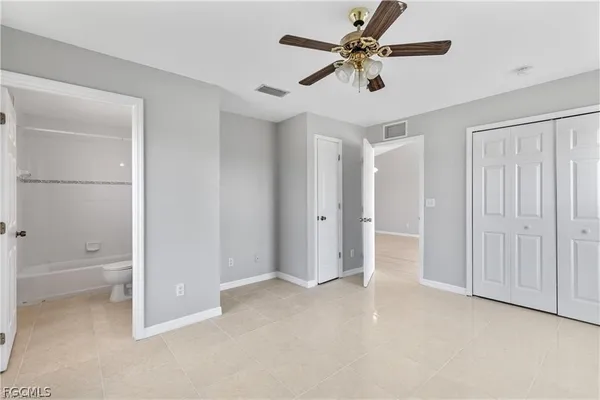 an empty room with windows and fan