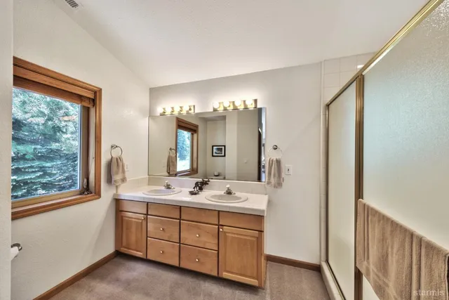 a bathroom with a double vanity sink and a mirror