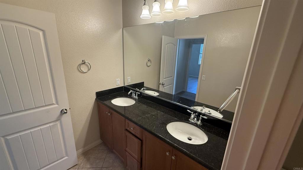 3422 Arborview Drive San Marcos, CA 92078 - Photo 17 of 21 a bathroom with a granite countertop sink and a mirror