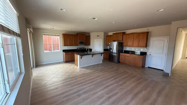 a kitchen with stainless steel appliances granite countertop a refrigerator stove top oven and sink