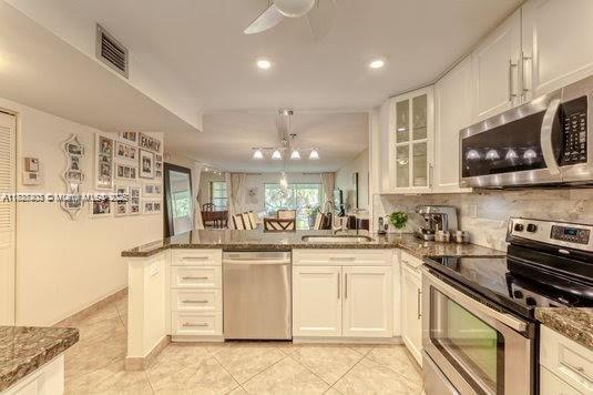 a kitchen with stainless steel appliances granite countertop a sink and cabinets
