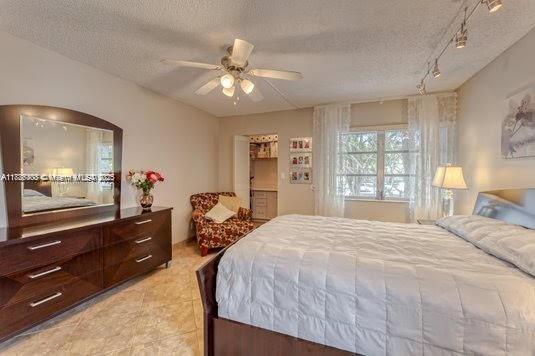 3772 Inverrary Boulevard, Unit 201 Lauderhill, FL 33319 - Photo 18 of 35 a bedroom with a bed and a dresser with mirror