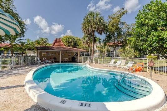 3772 Inverrary Boulevard, Unit 201 Lauderhill, FL 33319 - Photo 31 of 35 a view of a swimming pool with a patio