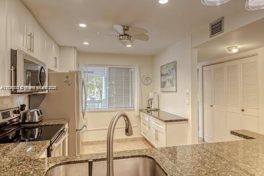 3772 Inverrary Boulevard, Unit 201 Lauderhill, FL 33319 - Photo 5 of 35 a view of a kitchen with stainless steel appliances granite countertop sink stove and refrigerator