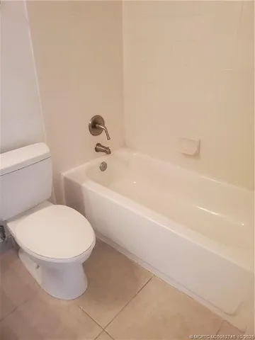 a white toilet sitting next to a bath tub