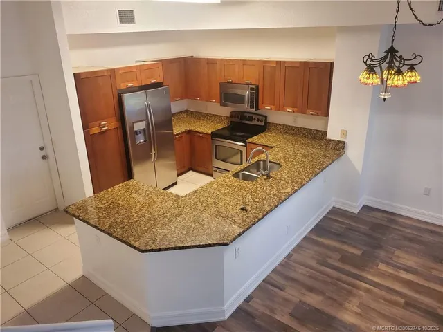 a kitchen with a sink and a wooden floor