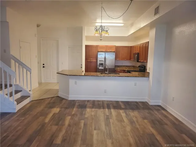 a view of a kitchen with a sink hardwood floor and a window