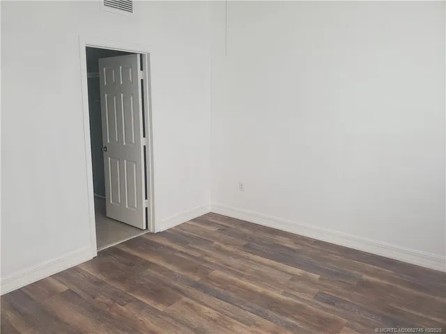 an empty room with wooden floor and closet