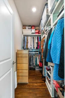 a view of walk in closet with clothes and shoes