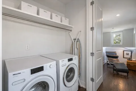 a view of washer and dryer with kitchen in the background