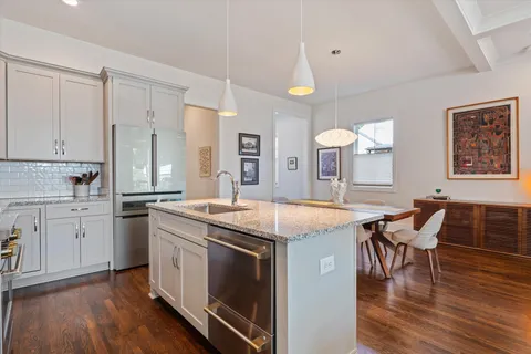 a kitchen with a stove a sink a dining table and chairs