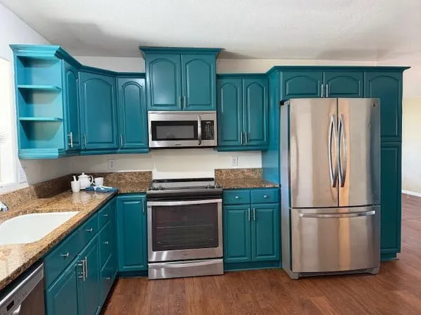 a kitchen with granite countertop stainless steel appliances and wooden cabinets