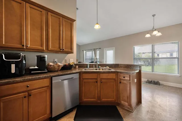 a kitchen with stainless steel appliances granite countertop a sink a stove cabinets and wooden floor