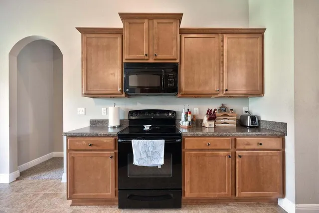 a kitchen with stainless steel appliances granite countertop a stove a sink and a microwave