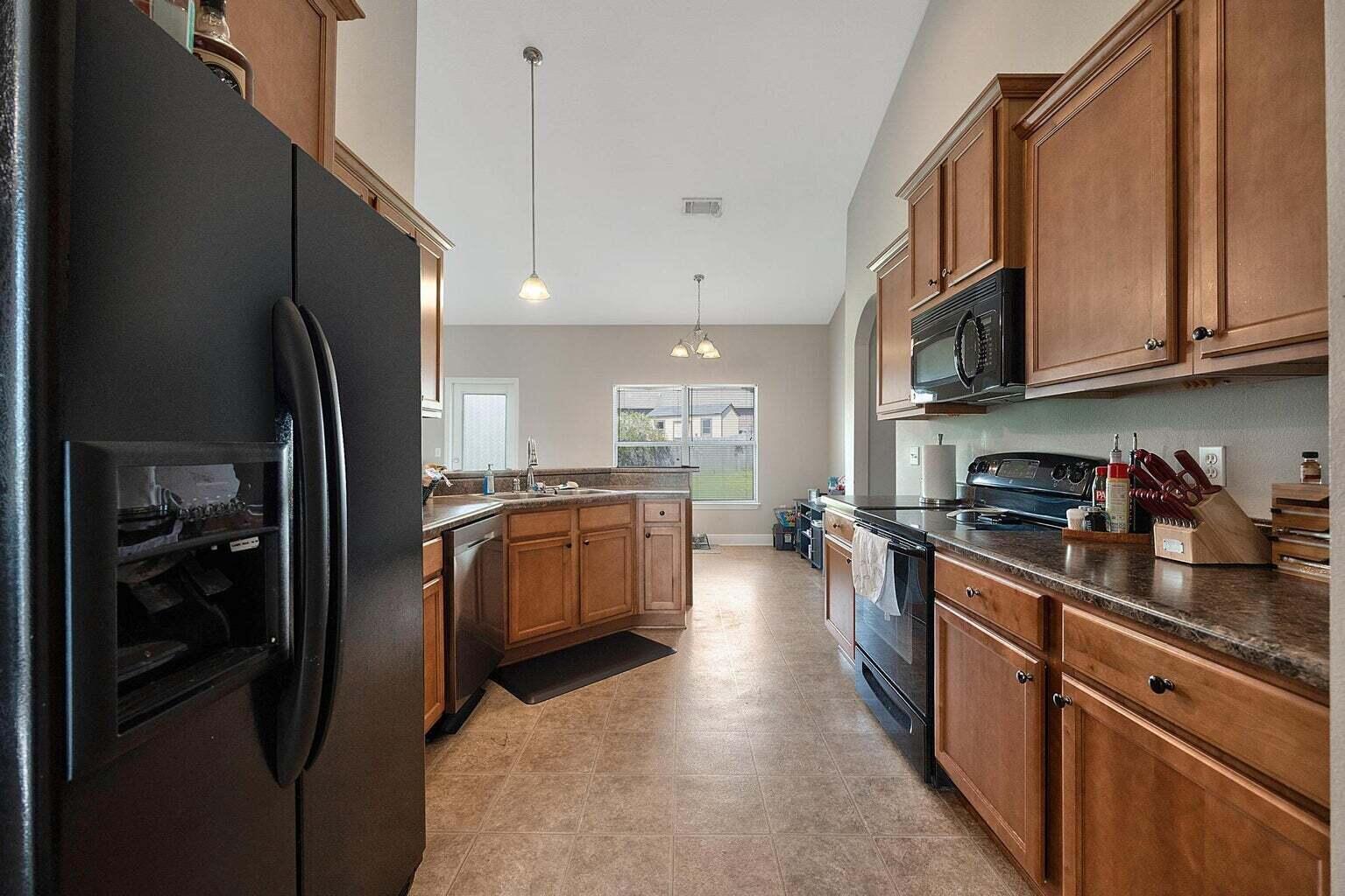 607 Rowan Circle Crestview, FL 32536 - Photo 13 of 27 a kitchen with stainless steel appliances granite countertop a refrigerator a stove and a sink