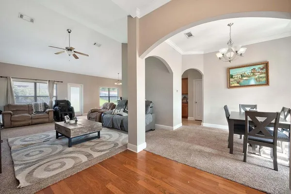 a living room with furniture two window and a dining table