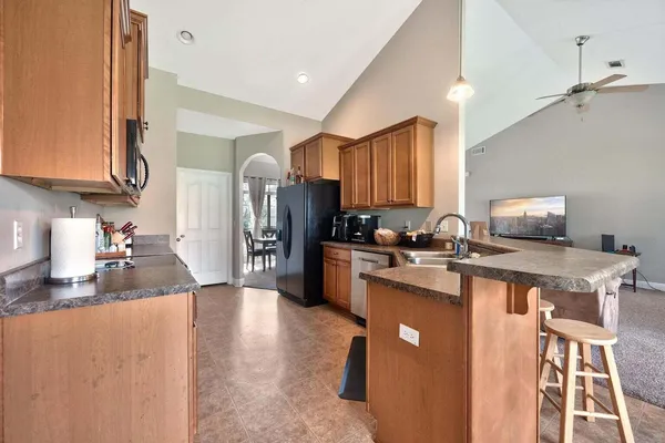 a kitchen with a refrigerator a sink dishwasher and a stove with wooden floor