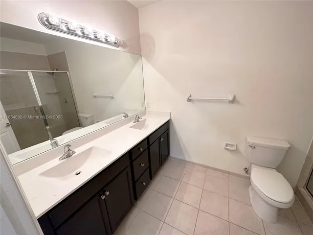 a bathroom with a double vanity sink mirror and toilet