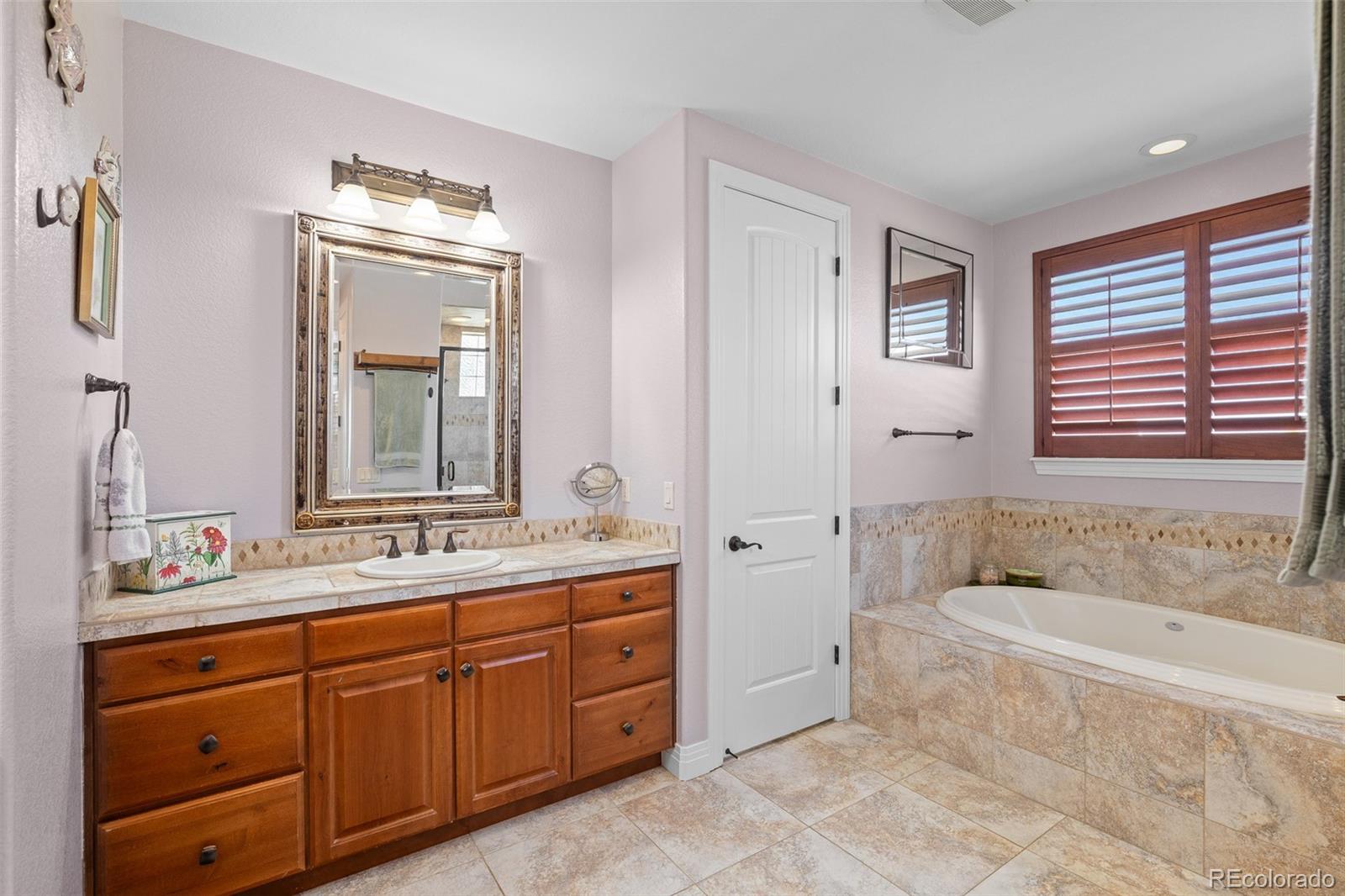 41865 East Muirfield Loop Elizabeth, CO 80107 - Photo 19 of 50 a spacious bathroom with a tub sink double and mirror
