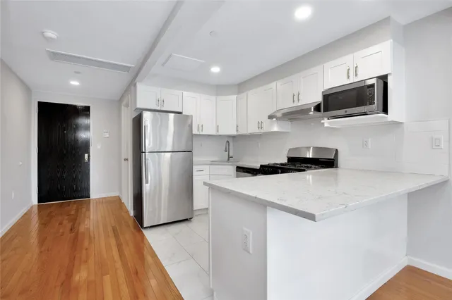 a kitchen with stainless steel appliances a refrigerator stove microwave and sink