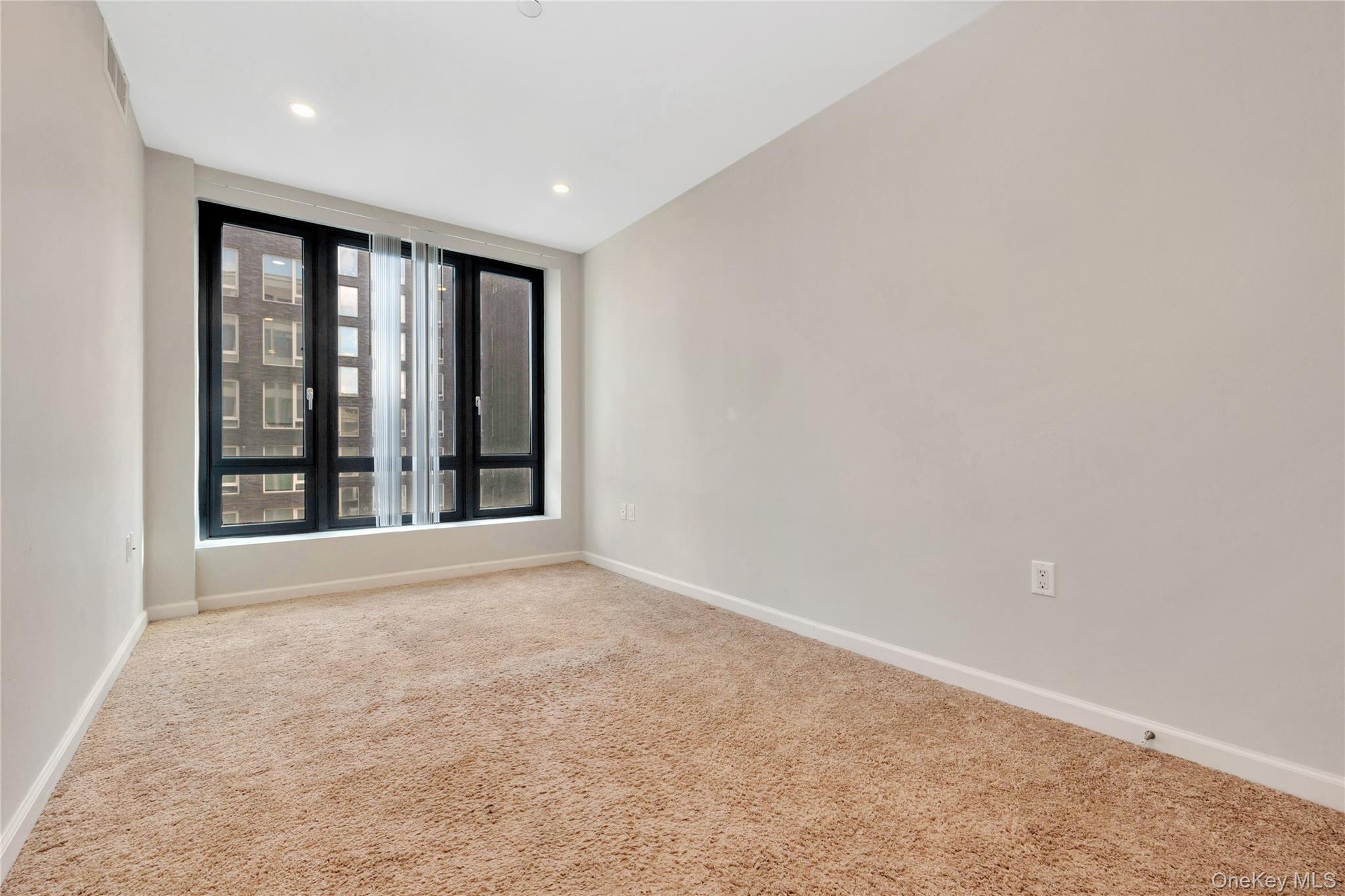 148-36 89th Avenue, Unit 204 Queens, NY 11435 - Photo 8 of 32 an empty room with large windows
