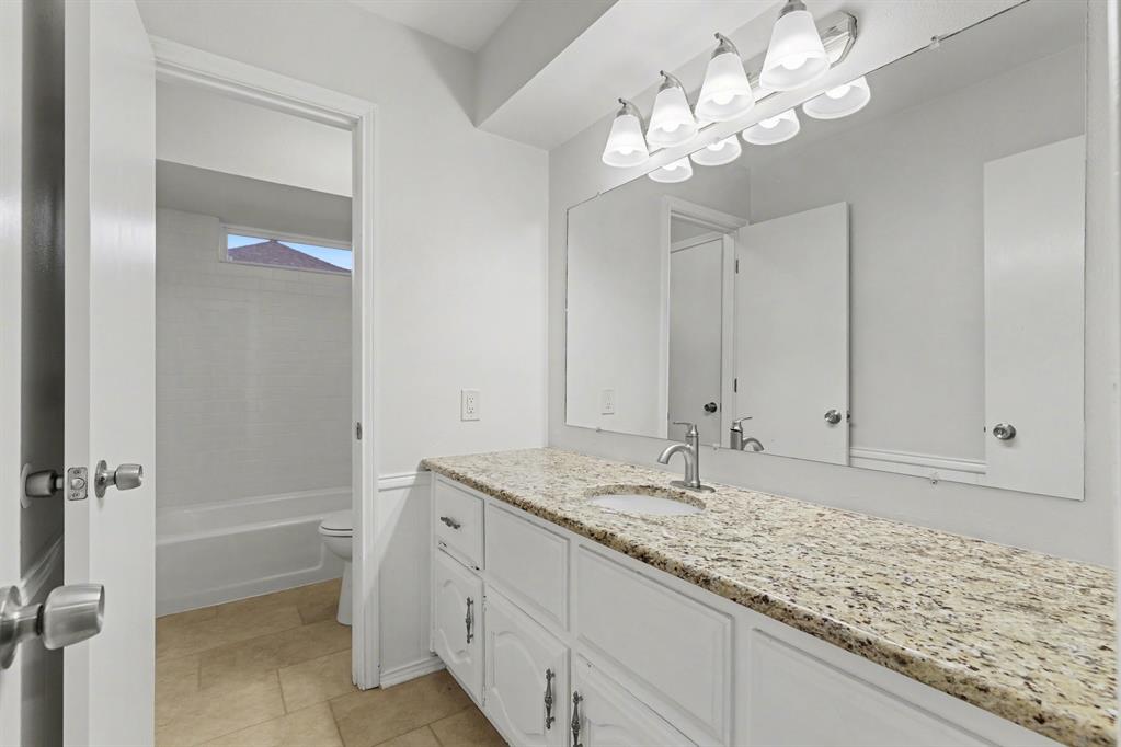 908 Thoreau Lane Allen, TX 75002 - Photo 22 of 31 a bathroom with a granite countertop sink a mirror and a shower