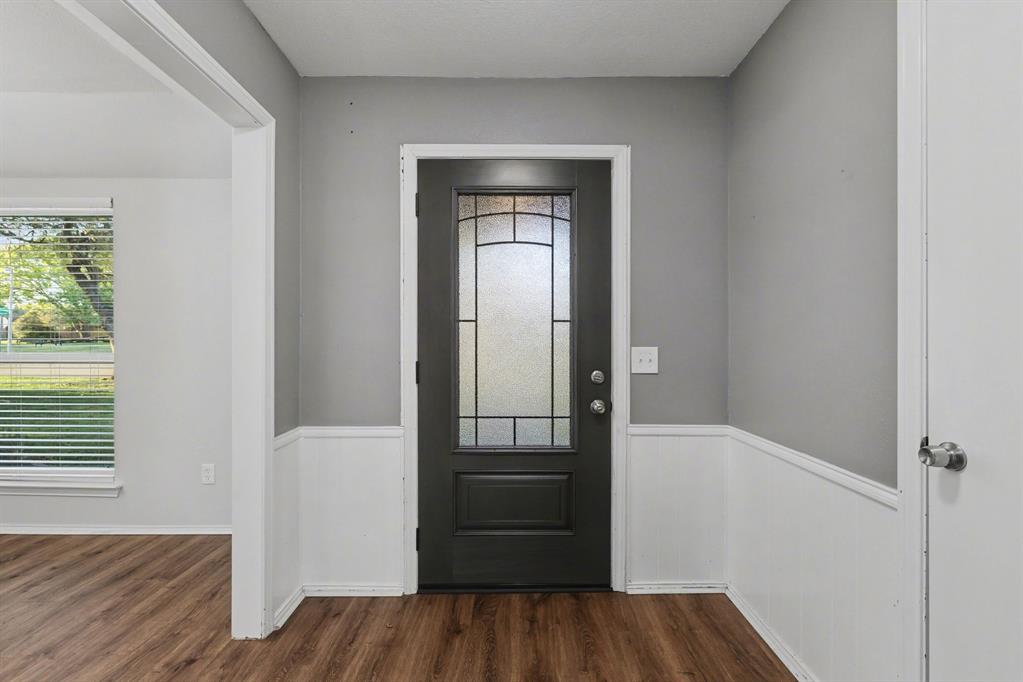 908 Thoreau Lane Allen, TX 75002 - Photo 3 of 31 an empty room with wooden floor cabinet and windows