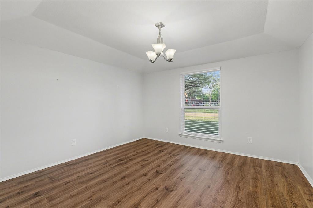 908 Thoreau Lane Allen, TX 75002 - Photo 5 of 31 an empty room with wooden floor chandelier fan and windows