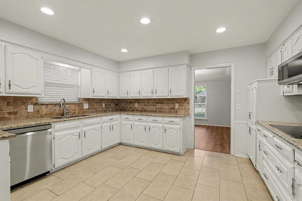 908 Thoreau Lane Allen, TX 75002 - Photo 6 of 31 a kitchen with granite countertop white cabinets and appliances