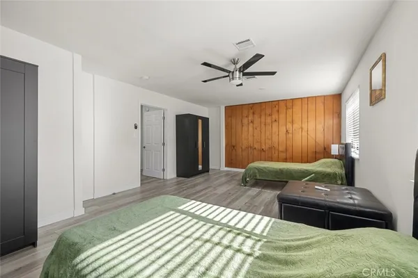 a spacious bedroom with a bed and wooden floor