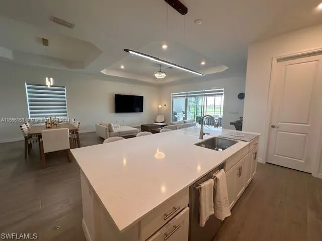a large white kitchen with a sink and a large window