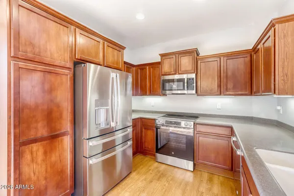 a kitchen with stainless steel appliances granite countertop a refrigerator and a sink