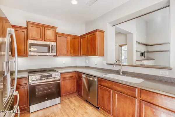 a kitchen with stainless steel appliances granite countertop a refrigerator and a sink