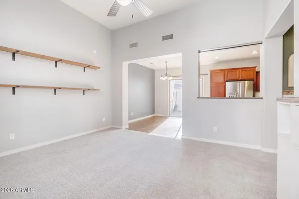 an empty room with windows and fan