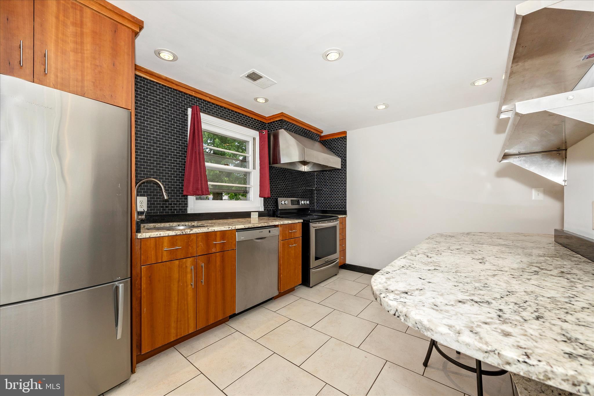17 East 13th Street Frederick, MD 21701 - Photo 13 of 53 a kitchen with stainless steel appliances granite countertop a sink and a refrigerator