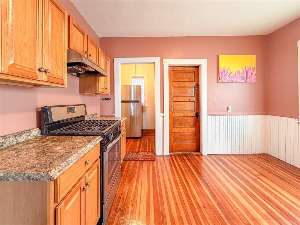 21 St Marks Road Boston, MA 02124 - Photo 5 of 30 a kitchen with stainless steel appliances granite countertop a stove and a wooden cabinets