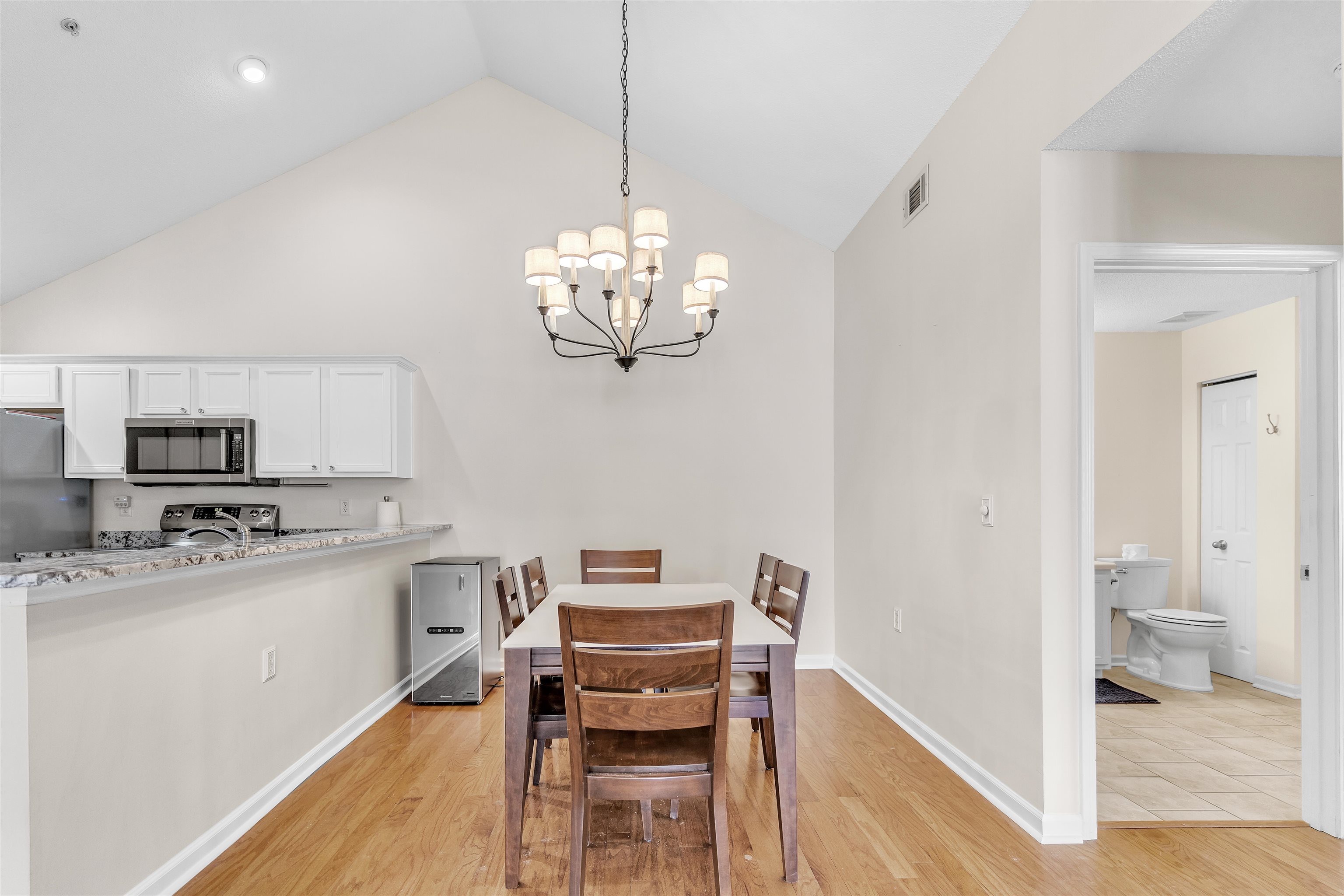 1213 Oak Timber Circle, Unit 25 Collierville, TN 38017 - Photo 10 of 25 Dining space featuring baseboards, visible vents, a chandelier, light wood-type flooring, and high vaulted ceiling