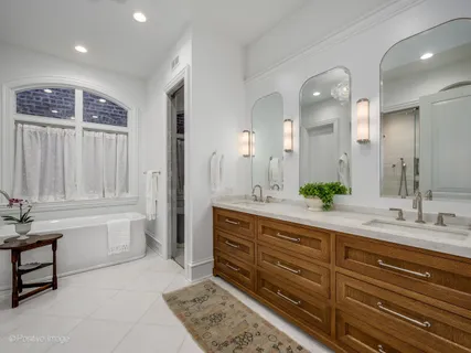 a spacious bathroom with a granite countertop sink mirror and bathtub
