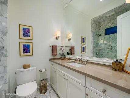 a bathroom with a granite countertop sink mirror vanity and toilet