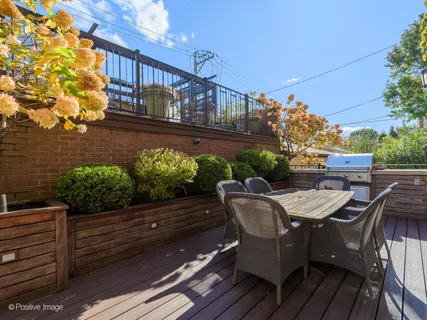 a view of a chairs and table on the deck in front of house